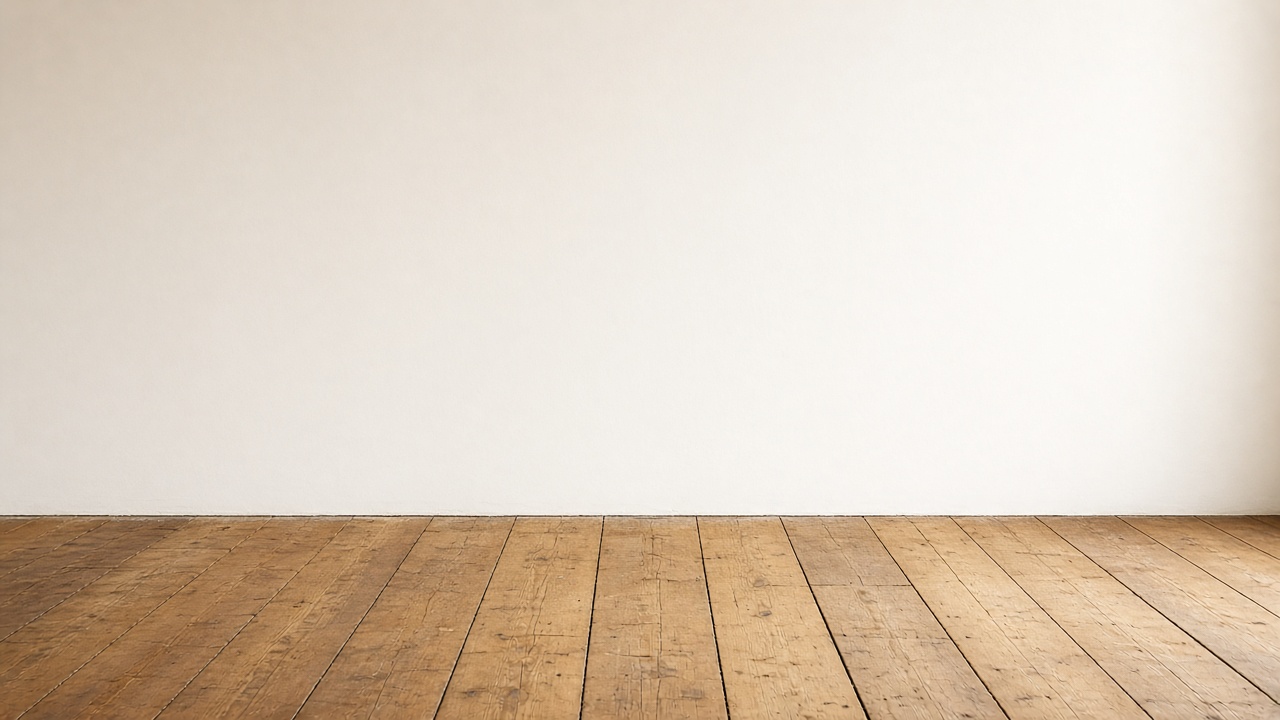 A freshly painted plain wall beside a worn wooden surface, with no sign