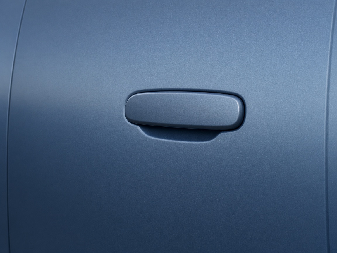 Close view of a body-colored door handle on a smooth blue car door, with no badges or lettering.